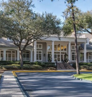 A building with a covered entrance, columns, and a staircase leading to the entrance. - Ocean Palms first floor villa - close to the beach - free golf (Hilton Head Island)