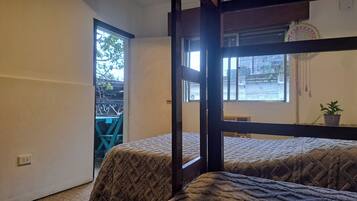 Una habitación con cama, ventana y vistas al exterior.
