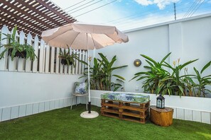 A patio area with a wooden pergola, a white fence, and potted plants. - Charming 4-bedroom townhome with AC, pool, and Wi-Fi in vibrant East Legon (Accra)