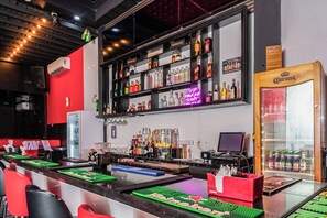 A bar area with a variety of liquor bottles, a neon sign, and a Corona beer box. - Shelbees Suites (Cornelia Ida)