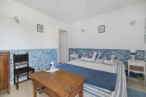 A bedroom with a bed, a wooden chair, a small table, and a nightstand. - Gentiane Room at Aux berges du Saint Ferréol (Les Brunels)