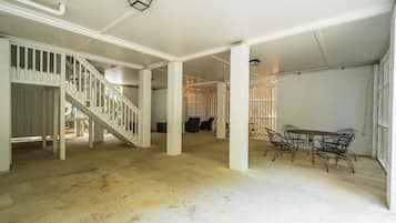 A spacious indoor area with a staircase, a dining table with chairs, and a garage door.