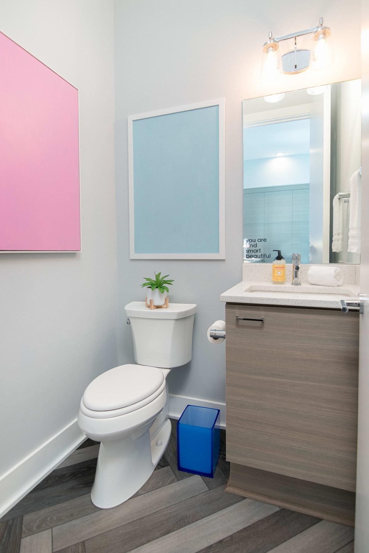 Un baño moderno con inodoro, lavamanos y espejo.