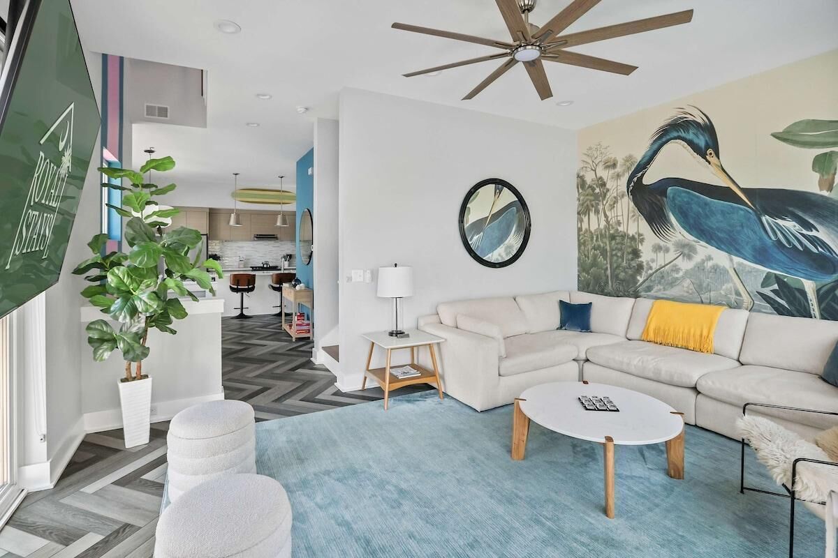 A modern living room with a sectional sofa, a round coffee table, and a ceiling fan.