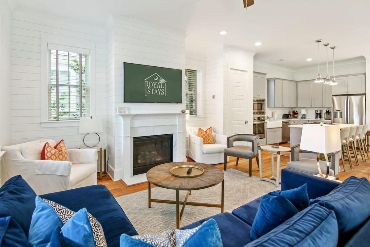 A spacious living room with a fireplace, a dining area, and a kitchen.