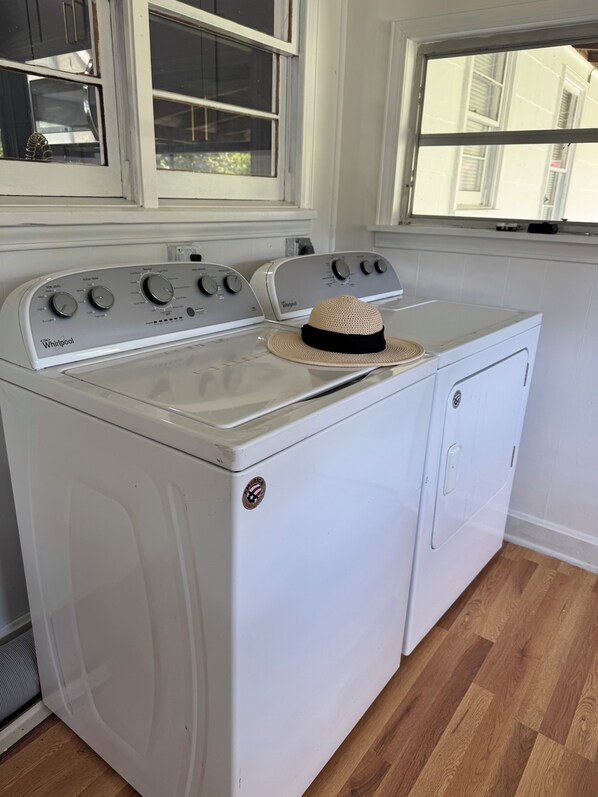 Una lavadora y secadora Whirlpool en una cocina con una ventana sobre los electrodomésticos.