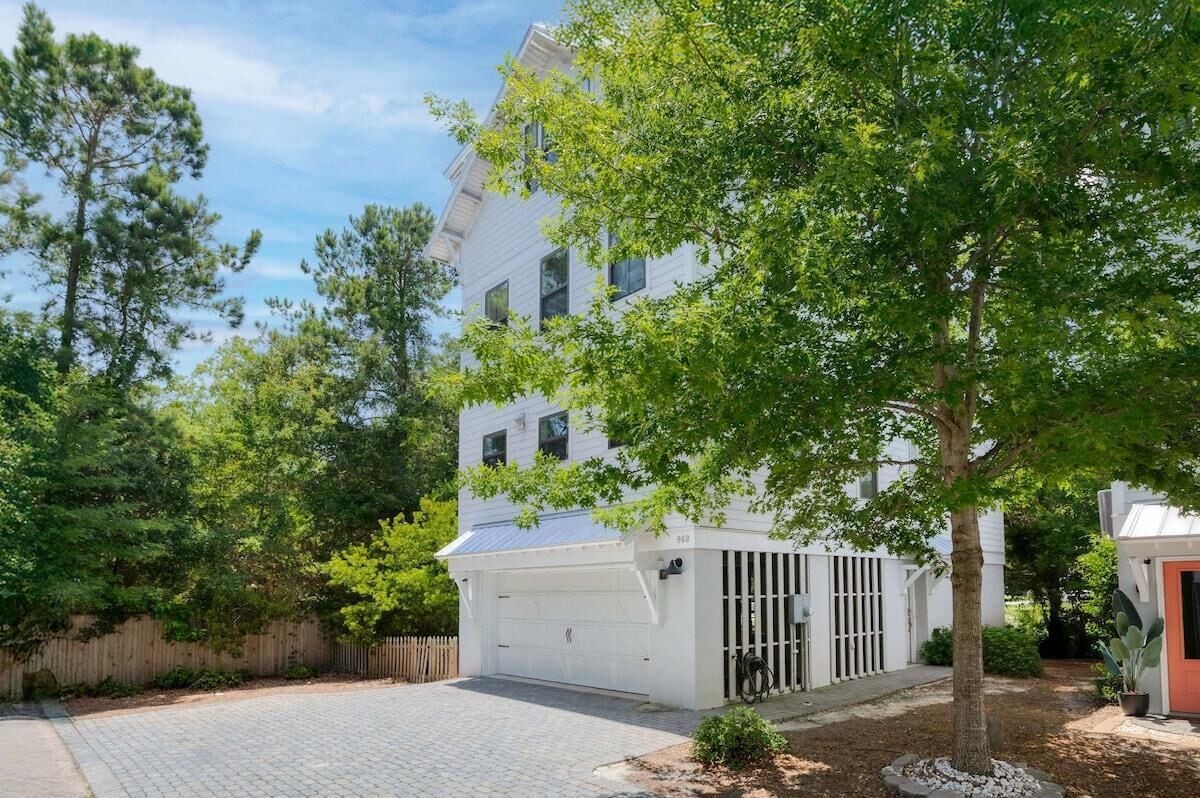 Un bâtiment blanc à deux étages, doté d’un garage et d’une petite dépendance attenante.