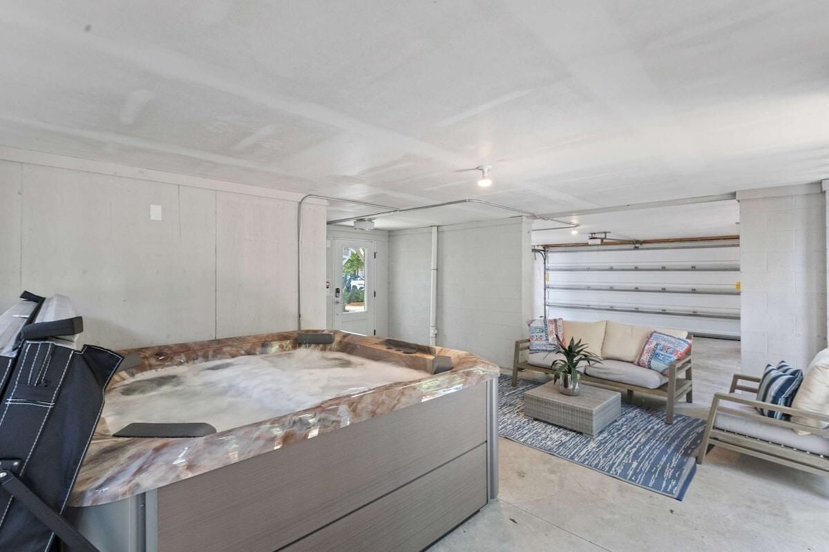 Ein moderner Spa-Bereich mit Whirlpool, Sitzgelegenheit und Blick auf die Garage.