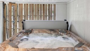 Ett bubbelbad med träpanel på utsidan och en kontrollpanel på sidan.
