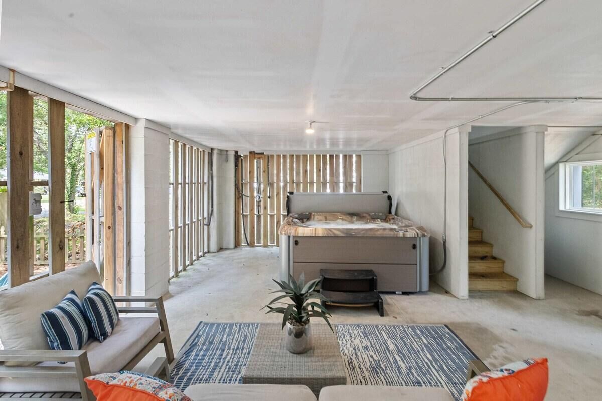 A spacious room with a large bed, a sofa, and a small table with a plant. There is a staircase leading to another level.