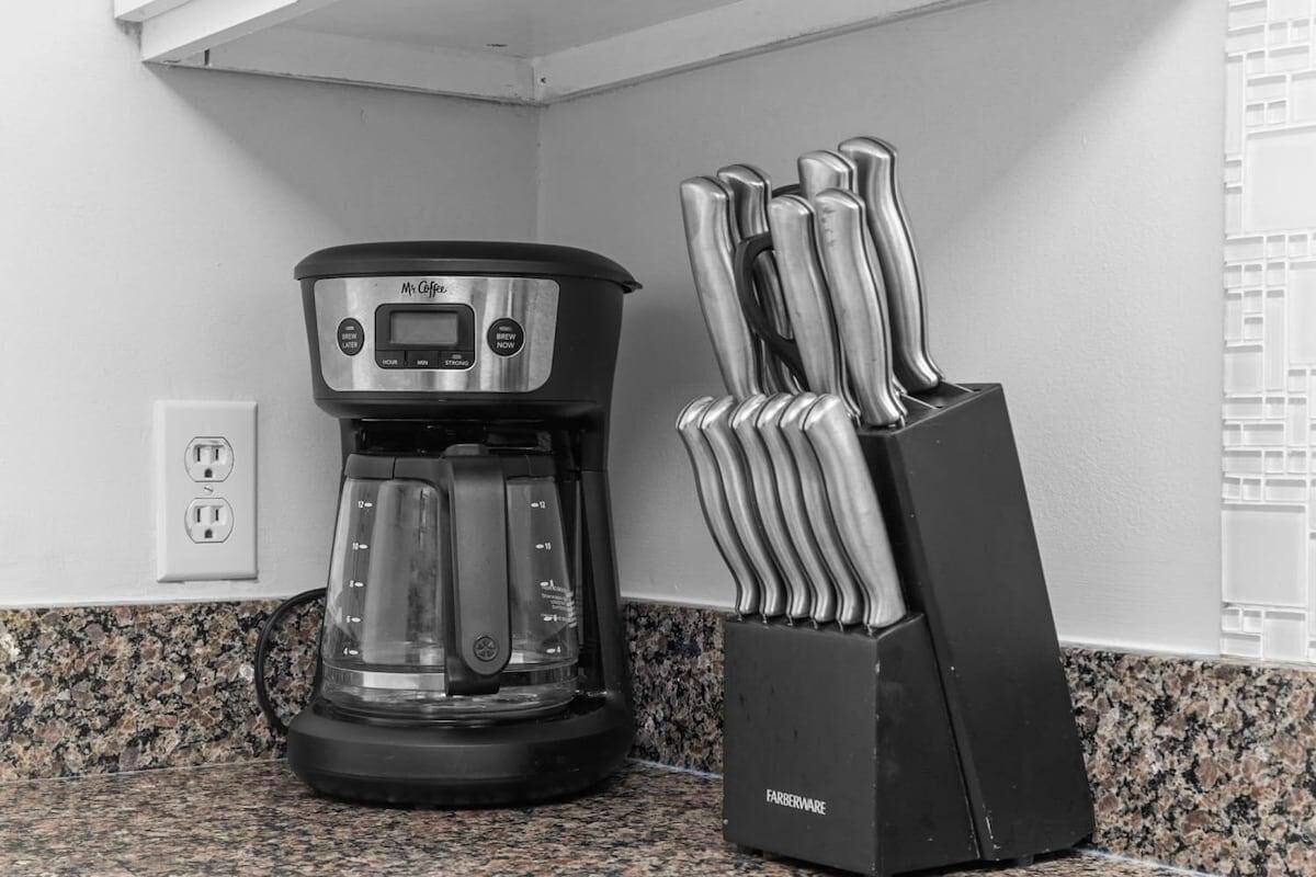 A kitchen with a coffee maker and a knife block.