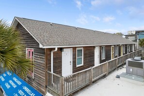 A wooden building with a porch, a door, and windows. - The Folly Feeling, 1 Block to Beach (Folly Beach)
