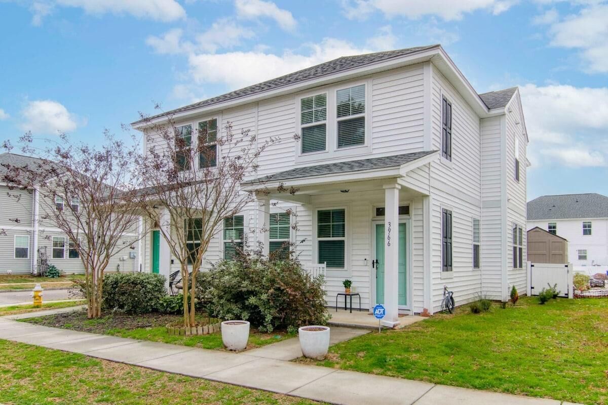 A two-story residential building with a porch, green shutters, and a number "3966" on the door.