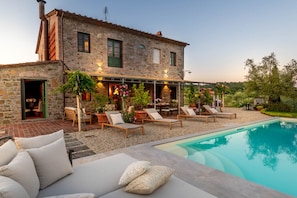 A stone house with a pool, outdoor seating, and a patio area. - Villa Pellegrini in Montecarlo (Montecarlo)