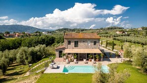 A stone villa with a swimming pool, surrounded by lush greenery and a clear sky. - Villa Pellegrini in Montecarlo (Montecarlo)