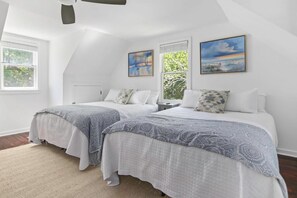 A bedroom with two beds, a ceiling fan, and artwork on the walls. - Sawyer's Landing- Mins to Beach & Dtwn (Mount Pleasant)
