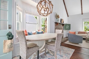 A dining area with wicker chairs, a wooden table, and a hanging light fixture. - Sawyer's Landing- Mins to Beach & Dtwn (Mount Pleasant)