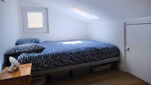 A small, single-bed room with a skylight, a window, and a door. - Charming apartment in Rezé near Sèvre (Rezé)