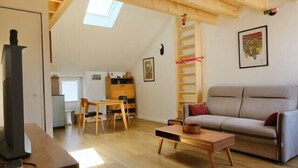 A living room with a sofa, a table, a fireplace, and a skylight. - Charming apartment in Rezé near Sèvre (Rezé)