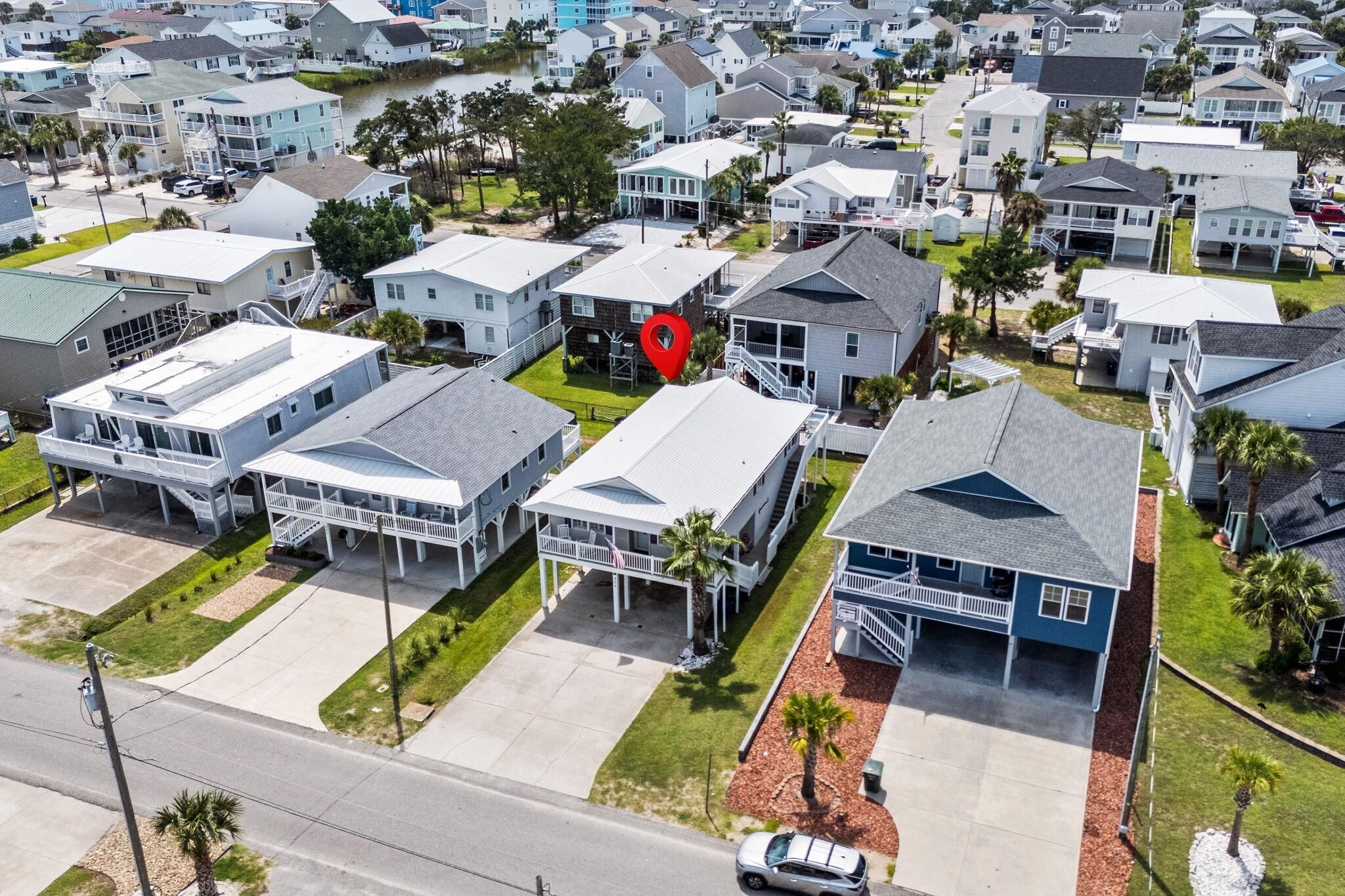 A residential area with houses featuring front porches and a central red location marker.