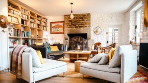 Una sala de estar acogedora con chimenea, estanterías y asientos cómodos.