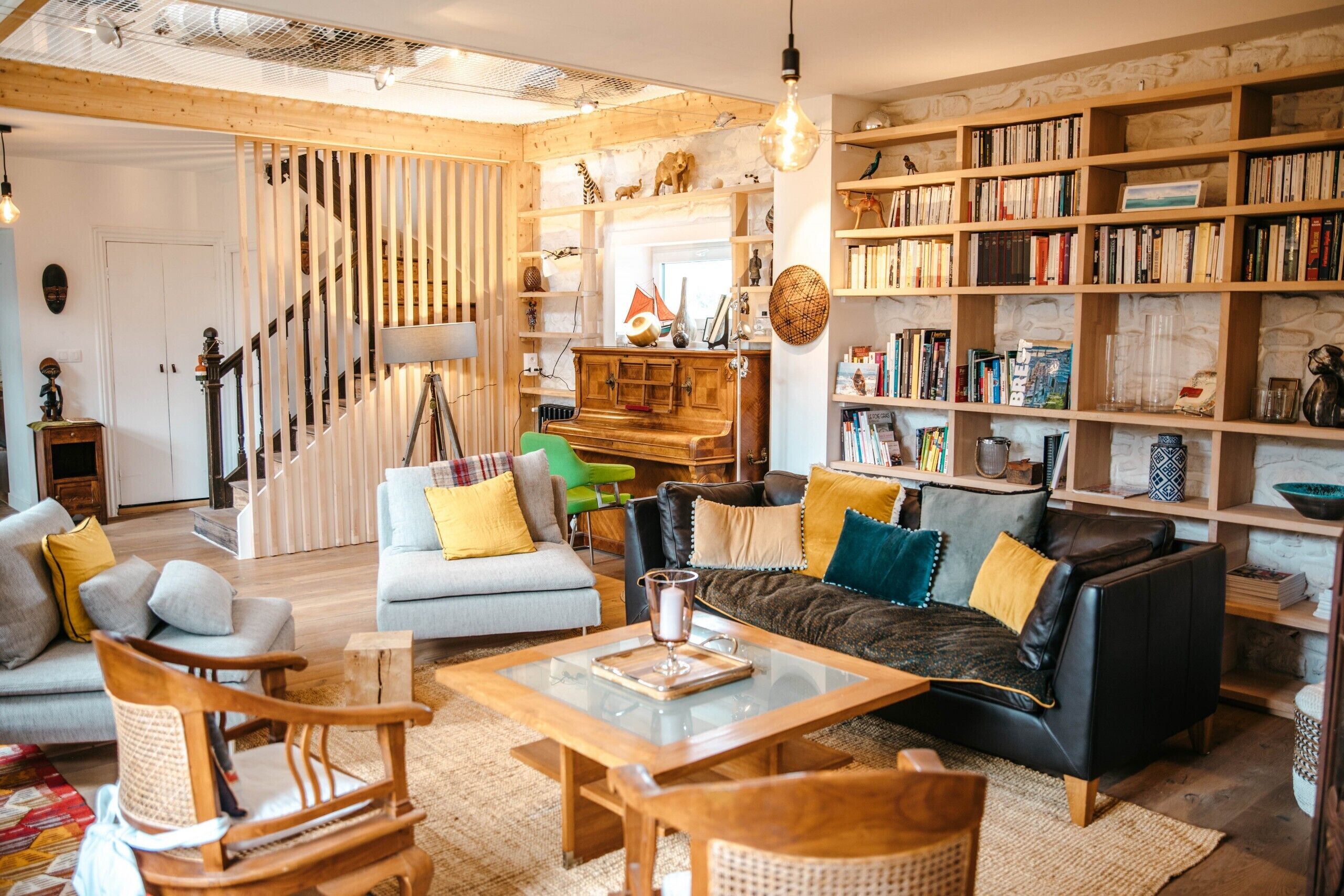 A cozy living room with a staircase, a bookshelf, and a coffee table.