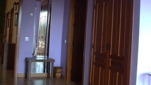 A hallway with wooden flooring, a large wooden wardrobe, and a mirror on the wall. - Rural House for Large Groups in Sierra de Gata, Cáceres, Extremadura (Cadalso)