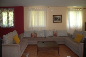 A living room with a sofa set, a coffee table, and curtains.