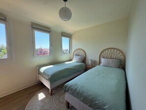 Ein Schlafzimmer mit zwei Betten, einem runden Teppich und einer Deckenleuchte.