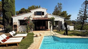A house with a swimming pool, lounge chairs, and a patio area. - Villa with sea view and swimming pool in St-Aygulf (Fréjus)