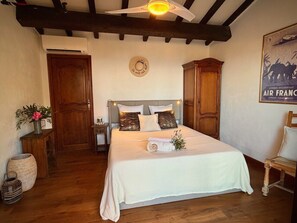 Ein Schlafzimmer mit einem Bett, einem Holzschrank und einem Deckenventilator.