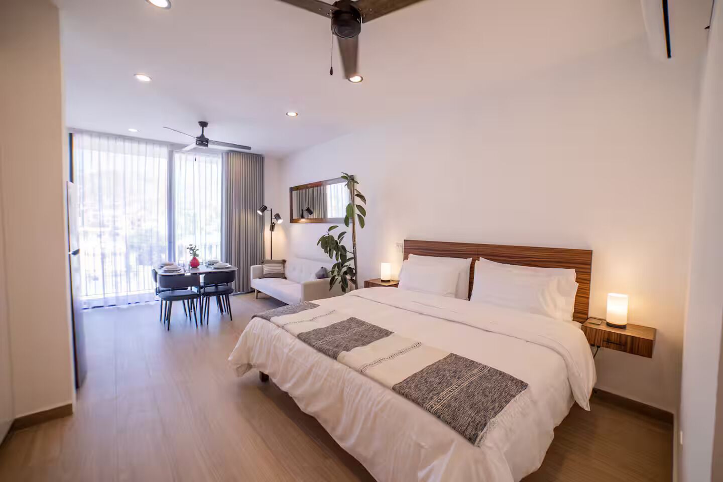 Ein Hotelzimmer mit einem großen Bett, Nachttischen, einem Schreibtisch und einem Sessel.