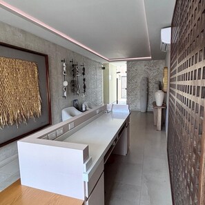 A modern kitchen with a long countertop, a hanging light fixture, and a decorative wall panel. - Cabo Studio 13. Three blocks away from the Marina. (Cabo San Lucas)