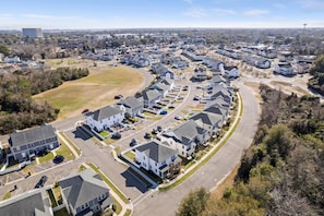 An aerial view of a residential area with houses, roads, and a large building in the background. - Creekside Bungalow-park Circle-15m Dtwn CHS (North Charleston)