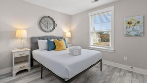 A bedroom with a bed, bedside tables, a window, and artwork on the walls. - Creekside Bungalow-park Circle-15m Dtwn CHS (North Charleston)