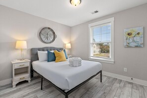 A bedroom with a bed, bedside tables, a window, and artwork on the walls. - Creekside Bungalow-park Circle-15m Dtwn CHS (North Charleston)
