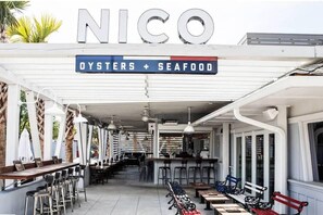Ein Restaurant namens 'NICO' mit einem Schild, das Austern und Meeresfrüchte anbietet.