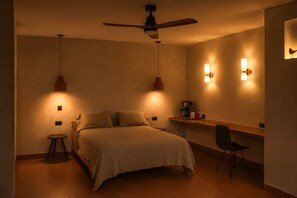 Ein Schlafzimmer mit Bett, Stuhl, Schreibtisch, Deckenventilator und Wandleuchten.