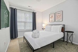 A hotel room with a bed, a bedside table, a lamp, and artwork on the wall. - Chucktown Charm- 8 Mins to Credit One (Charleston)