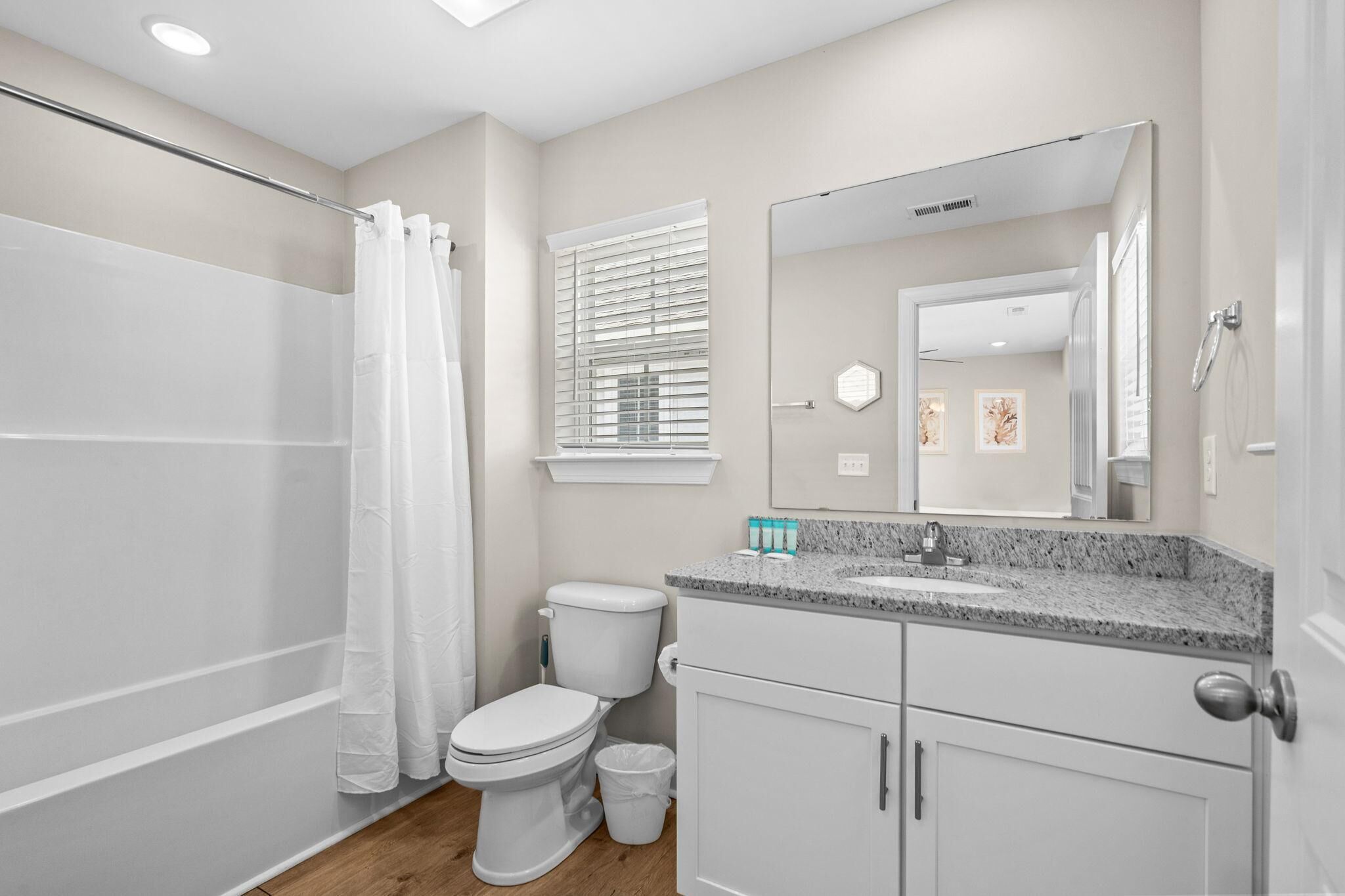 Une salle de bain équipée d’une douche, de toilettes, d’un lavabo et d’un miroir.