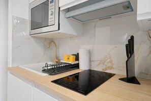 A kitchen with a microwave, stove, and sink. - Studio Apartment 'Cosy and Central' with Wi-Fi and Air Conditioning (Nice)