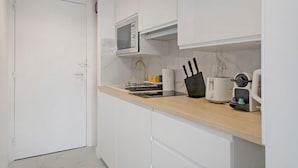 A modern kitchen with white cabinetry, a microwave, a coffee machine, and a toaster. - Studio Apartment 'Cosy and Central' with Wi-Fi and Air Conditioning (Nice)
