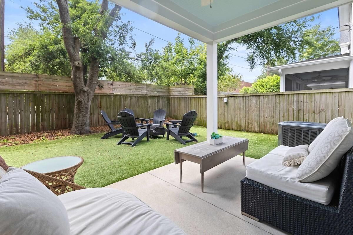 An outdoor patio area with a covered seating area, a dining table, and chairs.
