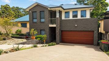 A two-story house with a garage, a balcony, and a driveway.