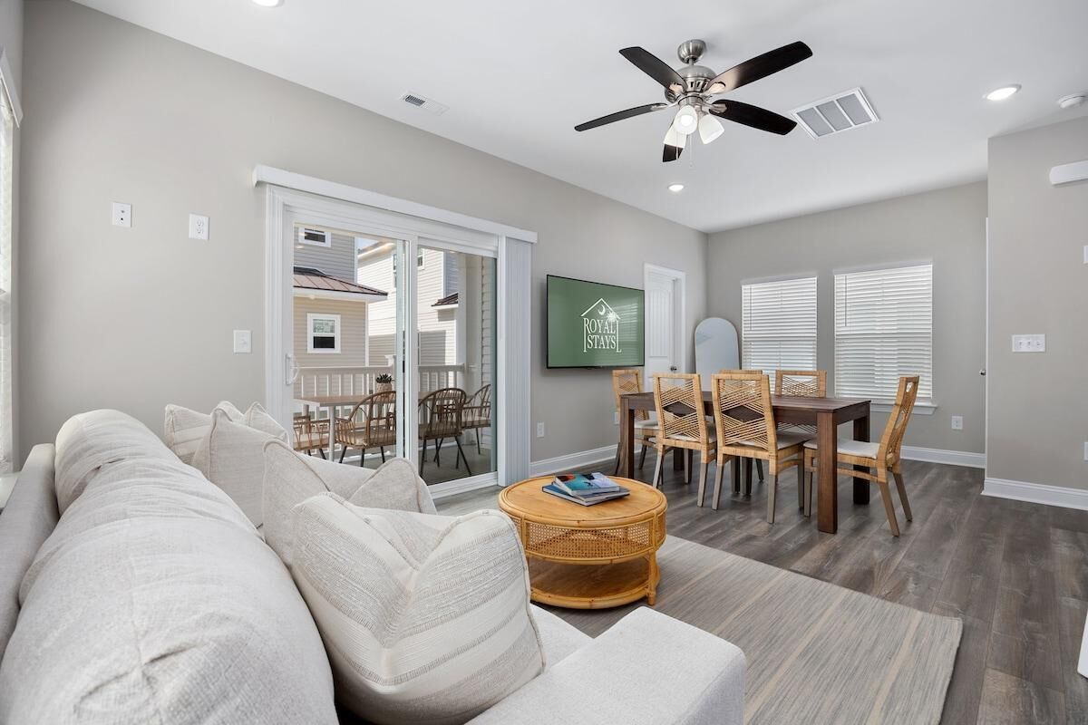 A living room with a sofa, a round coffee table, and a dining area with chairs and a table.