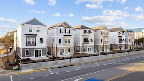 A row of modern, two-story townhouses with balconies, a paved driveway, and a clear sky. - Sea Cloud-across Ocean-pet Friendly! (Myrtle Beach)