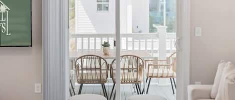 Una sala de estar moderna con un gran ventanal corredero que da a un patio exterior.