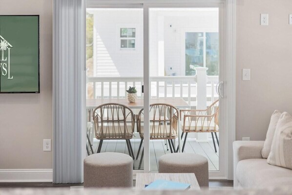 A modern living room with a sliding glass door leading to an outdoor patio. - Capers Blade-across Beach-garage (Myrtle Beach)