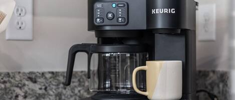 Máquina de café Keurig em bancada de cozinha, com uma caneca.
