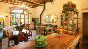 A cozy restaurant interior with wooden furniture, a green centerpiece, and a vintage display case. - Pool villa with panoramic view in Cortona (Sodo)